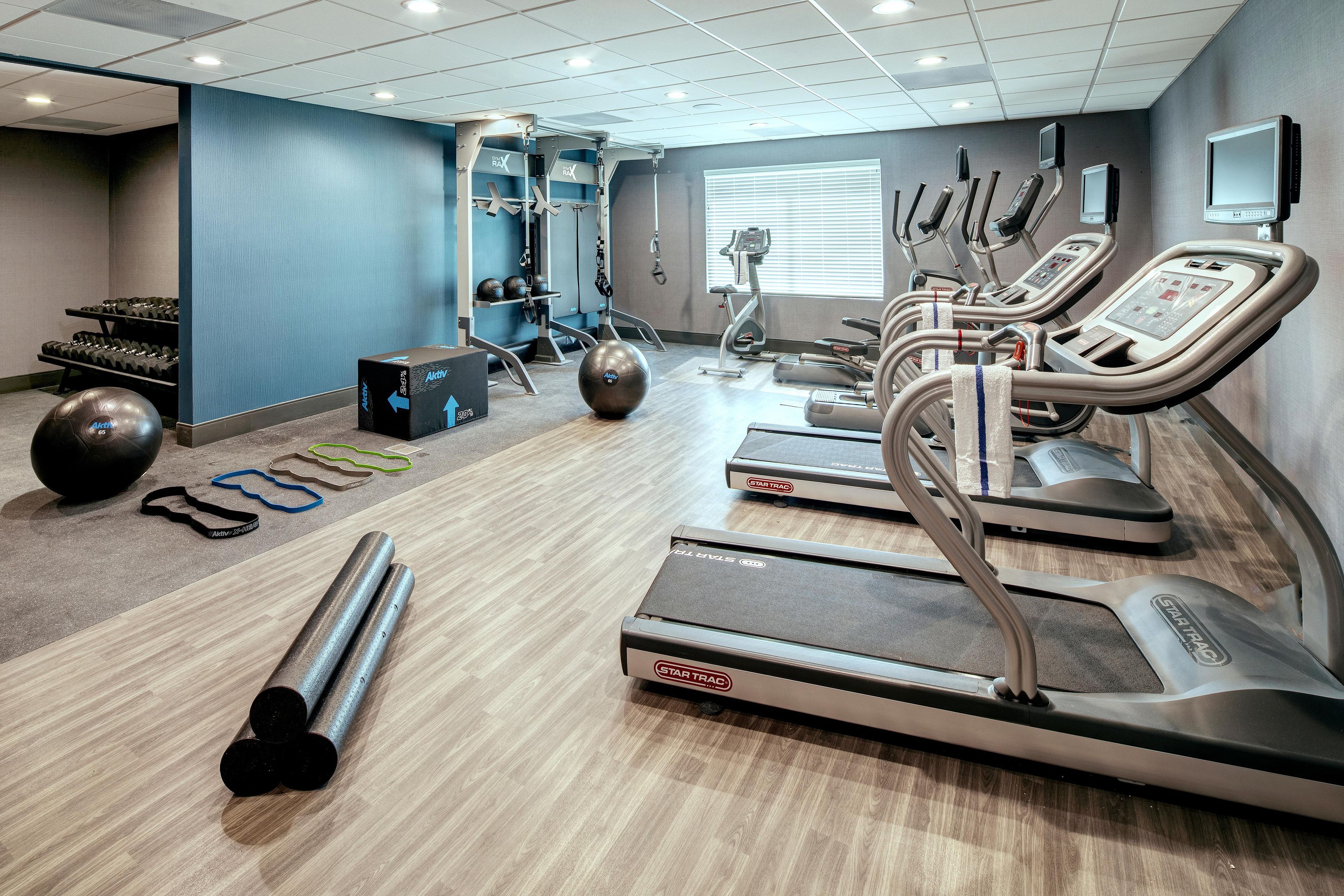 A gym with treadmills, exercise balls, and weight machines.
