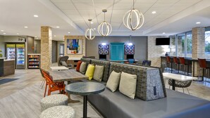 A modern lounge area with a seating area, a counter, and a beverage station. - Home2 Suites by Hilton Palm Bay Melbourne I 95 (Palm Bay)