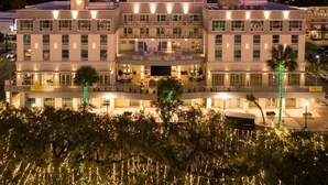 A multi-story hotel with a central atrium, balconies, and outdoor seating areas. - Hilton Garden Inn Ocala Downtown (Ocala)