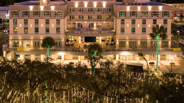 A multi-story hotel with a central atrium, balconies, and outdoor seating areas. - Hilton Garden Inn Ocala Downtown (Ocala)