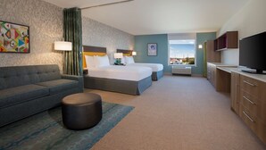 A hotel room with a bed, a sofa, a TV, and a window with a view. - Home2 Suites by Hilton Lewes Rehoboth Beach (Lewes)