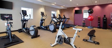 A gym with stationary bikes, treadmills, and a rowing machine.