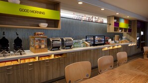 A modern breakfast bar with a 'Good Morning' sign, a 'Inspired Table' sign, and a variety of breakfast items. - Home2 Suites by Hilton Lewes Rehoboth Beach (Lewes)