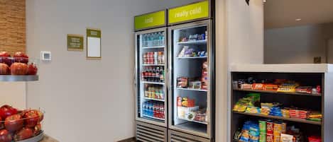 A vending area with two refrigerated beverage dispensers labeled "cold" and "really cold," and a snack shelf stocked with various chips and snacks.