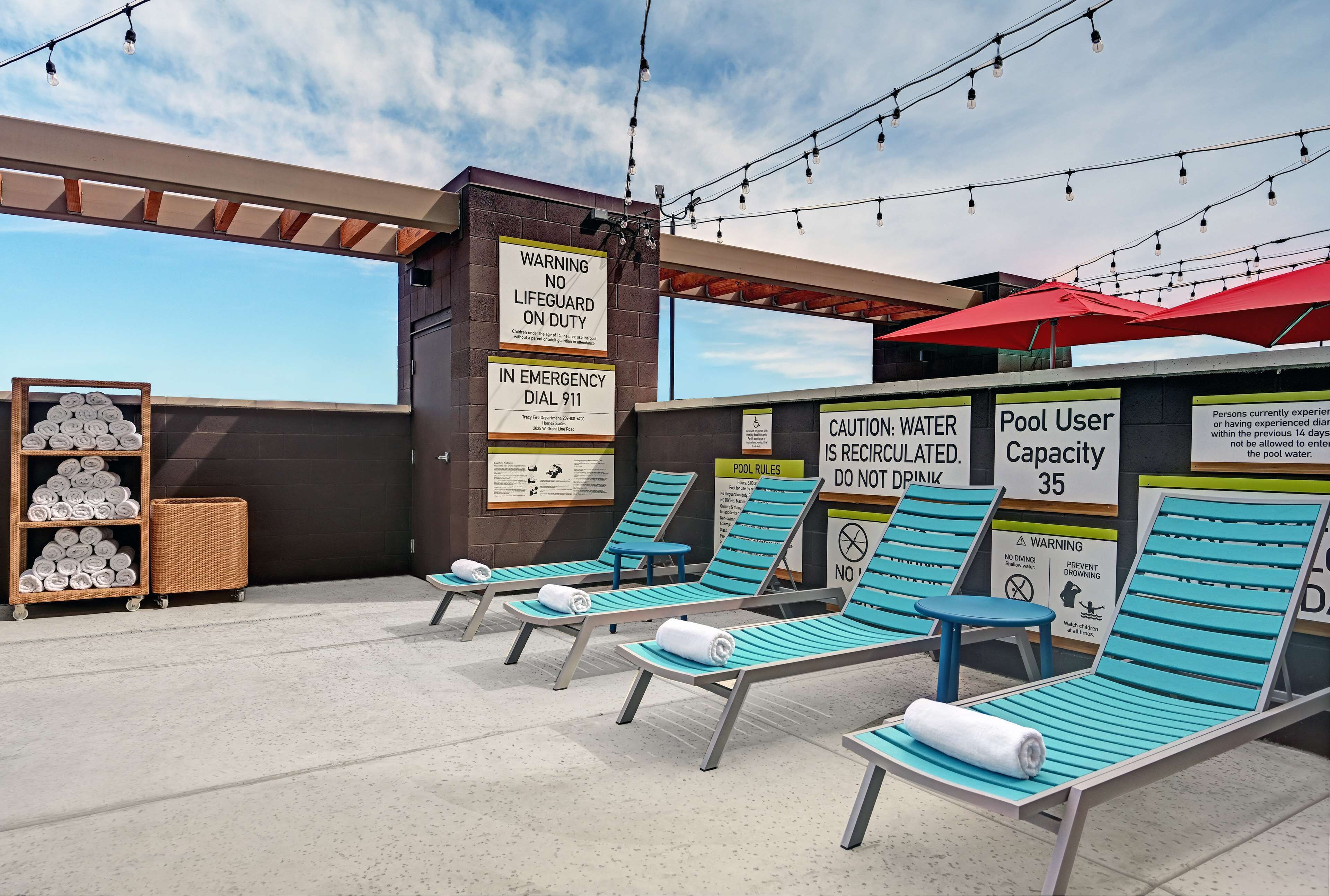 Een buitenzwembad, ligstoelen bij het zwembad