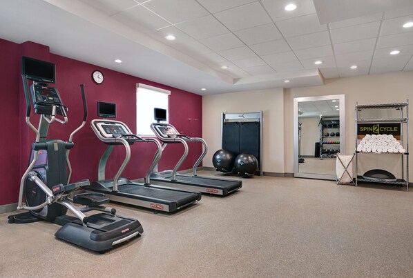 A gym with treadmills, an elliptical, and a spin bike. - Home2 Suites by Hilton Tracy (Tracy)