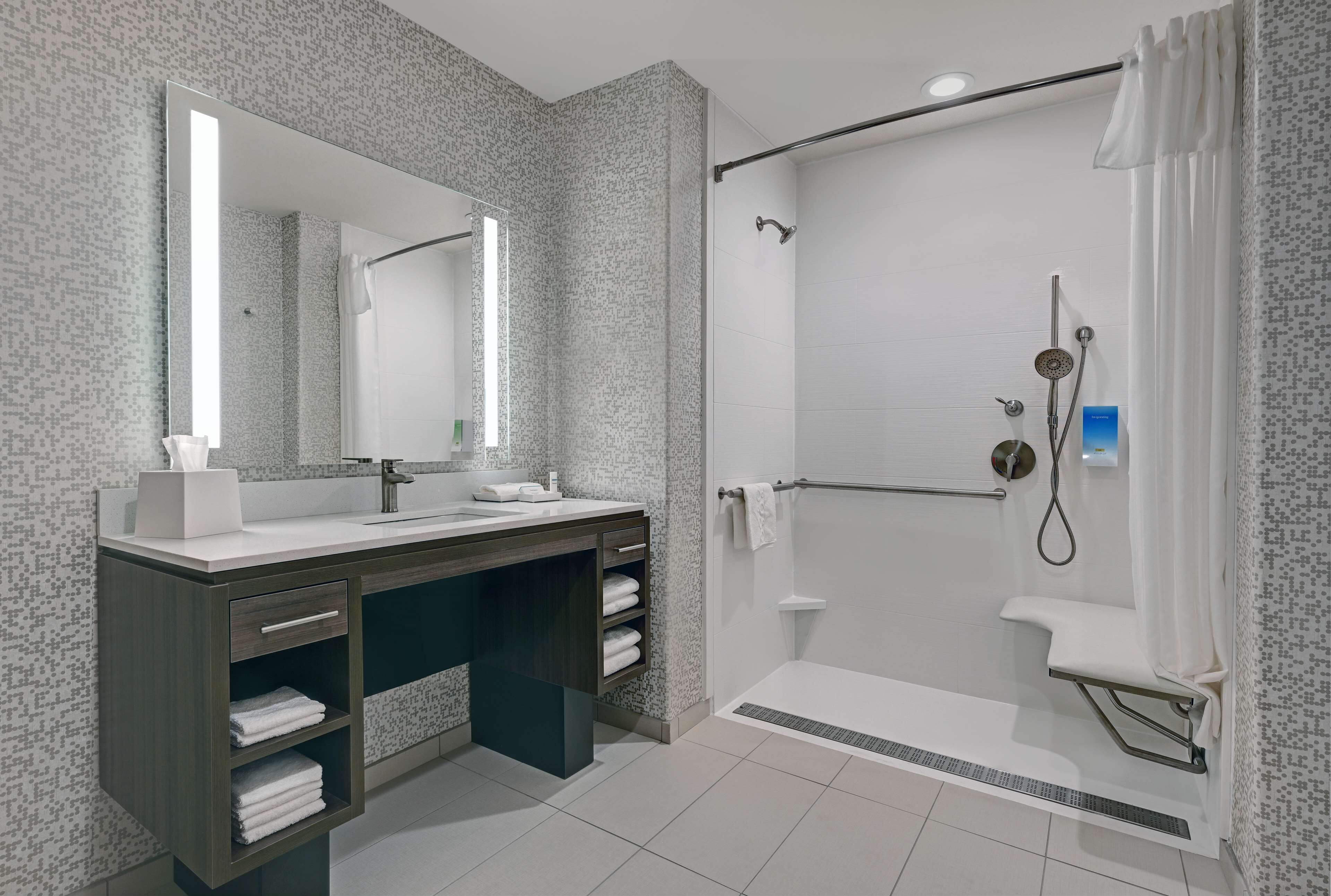 A modern bathroom with a shower, a vanity with a mirror, and a towel rack.