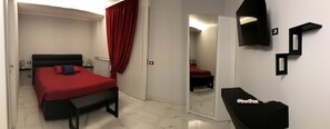 A bedroom with a bed, a bench, a mirror, and a small table. - Casa della Zia Elsa (Verona)