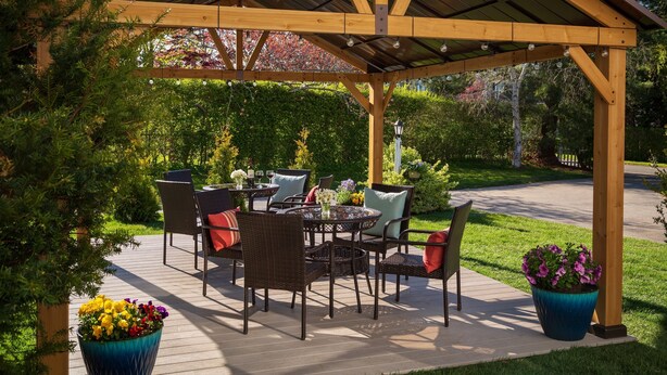 A covered patio area with outdoor furniture and potted plants. - King with Kitchenette and Fireplace, Private Bath, Parking, Walk to all (Newport)