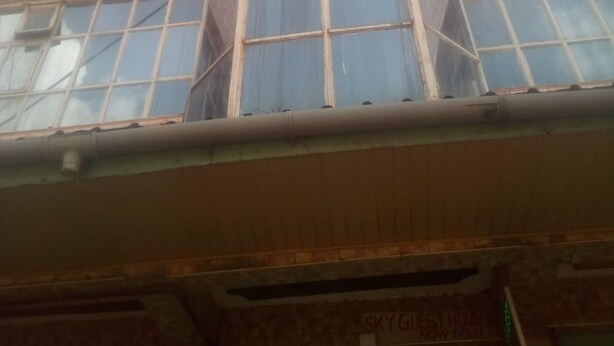 A multi-story building with a prominent glass facade and a sign indicating "Sky Guest House Now Open". - Sky Guest House (Nairobi)