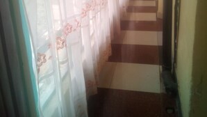 A corridor with patterned curtains and a checkered floor. - Sky Guest House (Nairobi)