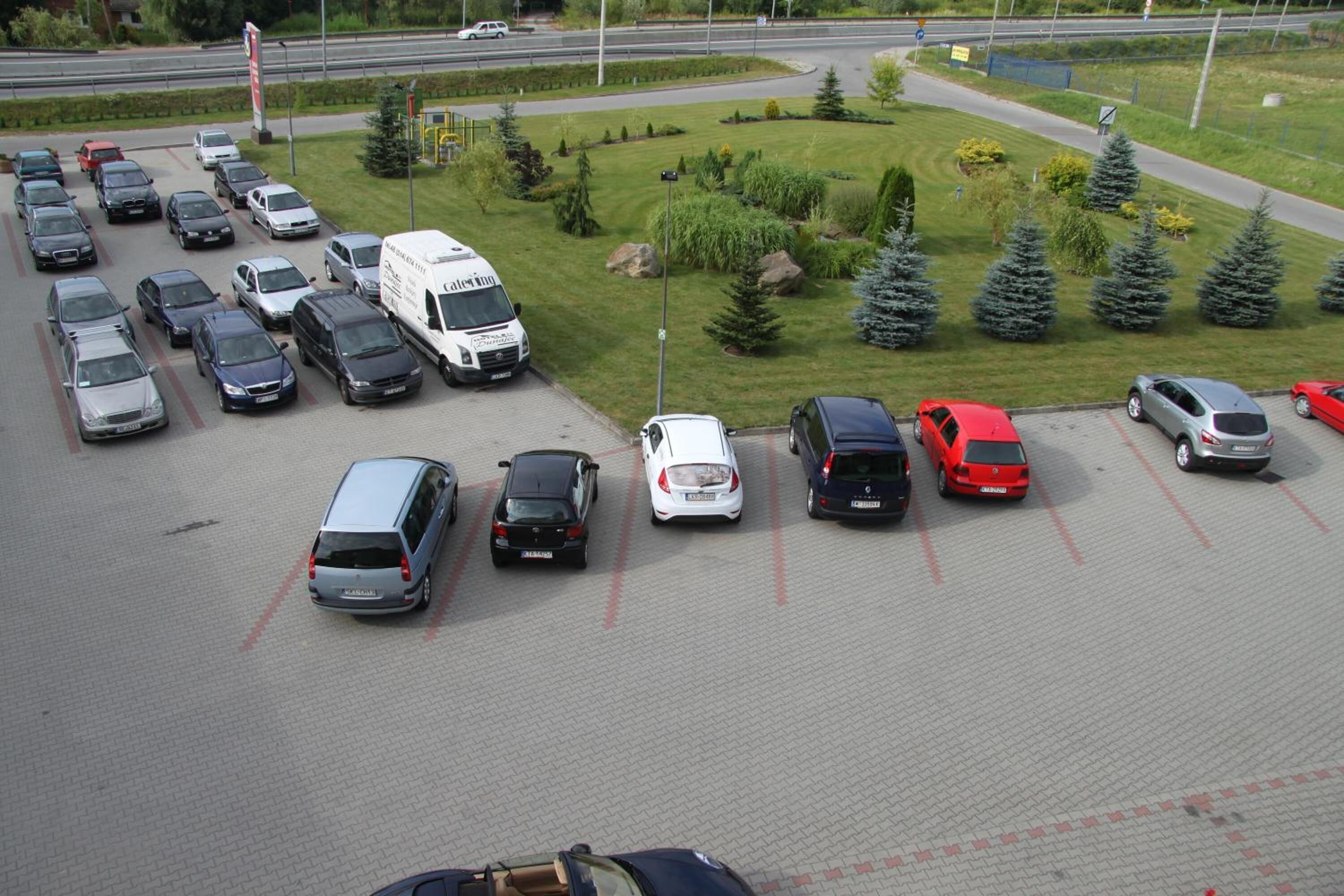 Un estacionamiento con varios autos y una camioneta blanca.