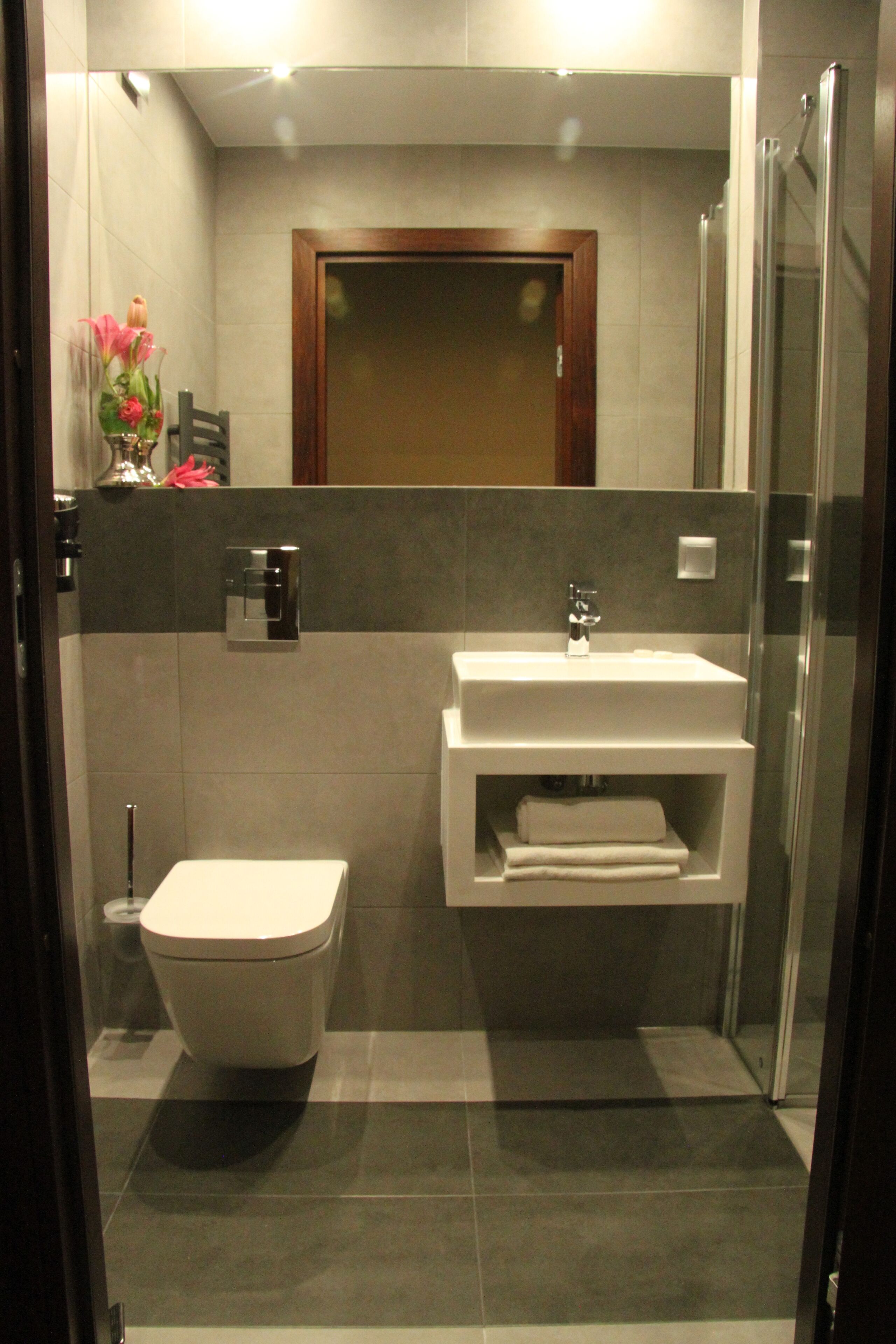 A modern bathroom with a toilet, a sink, and a shower.