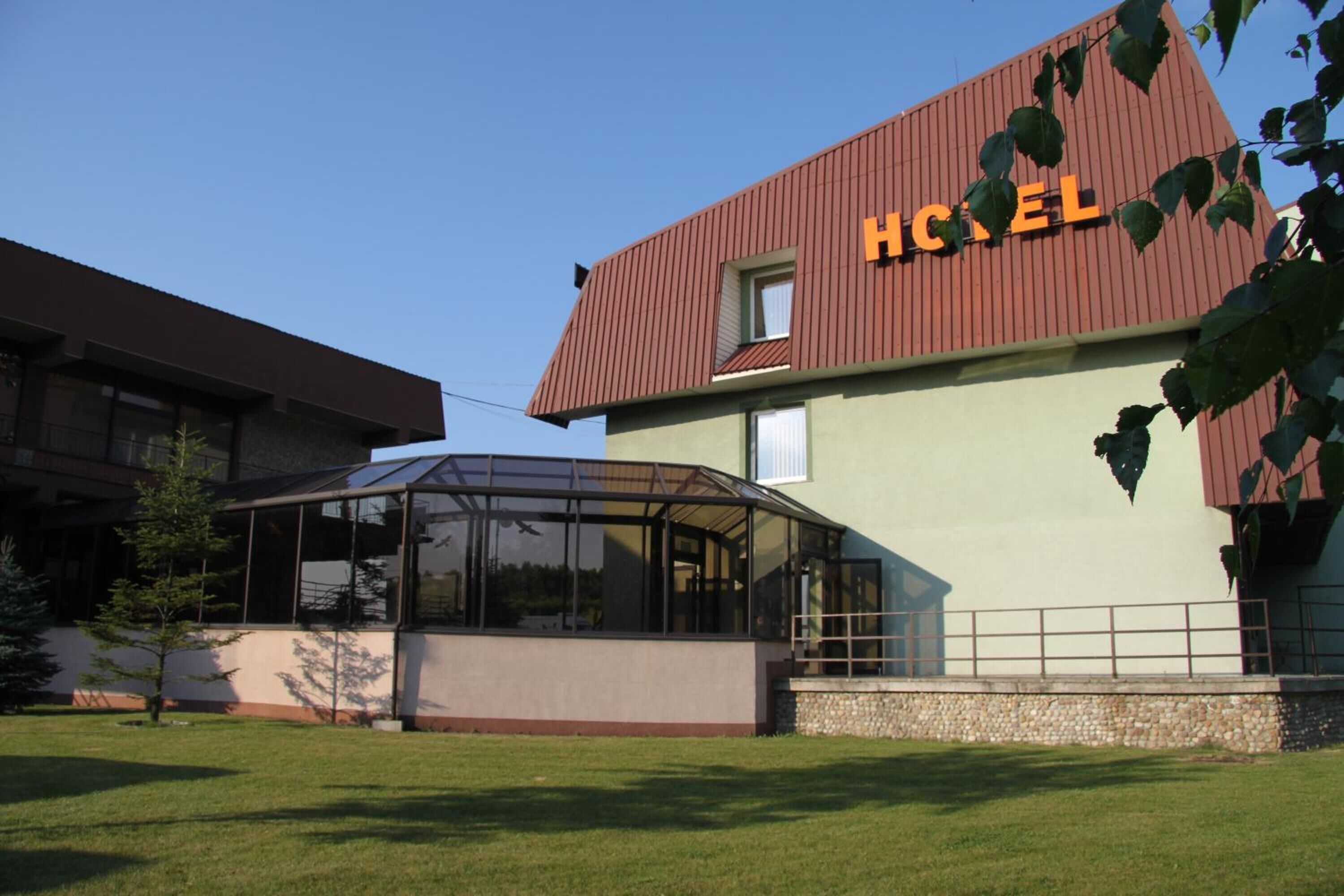 Et hotel med et stort glaskonglomerat og et tydeligt 'HOTEL' skilt på facaden.