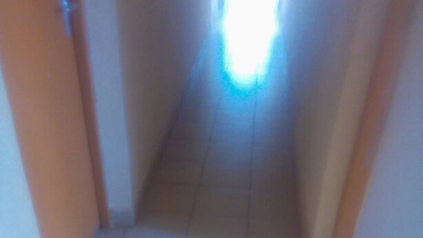 A narrow hallway with tiled flooring and plain walls. - Club Dee Hotel (Kagio)
