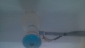 A ceiling fan with a blue light fixture, a visible electrical wire, and a window with daylight coming through. - Club Dee Hotel (Kagio)