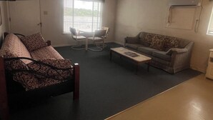 A living room with a sofa, a chair, a coffee table, and a television.