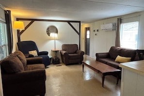A living room with two sofas, a coffee table, a lamp, and a fireplace.