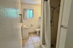 Ein Badezimmer mit Toilette, Dusche und Fenster.