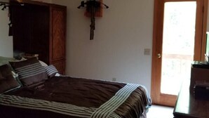 A bedroom with a bed, a ceiling fan, a wardrobe, a door, and a small table. - Fishing, Boating, Golf , Hunting - perfect getaway. Near Augusta for Masters (McCormick)