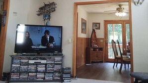 A living room with a mounted deer head, a mounted cow hide, a television, and a bookshelf filled with DVDs. - Fishing, Boating, Golf , Hunting - perfect getaway. Near Augusta for Masters (McCormick)