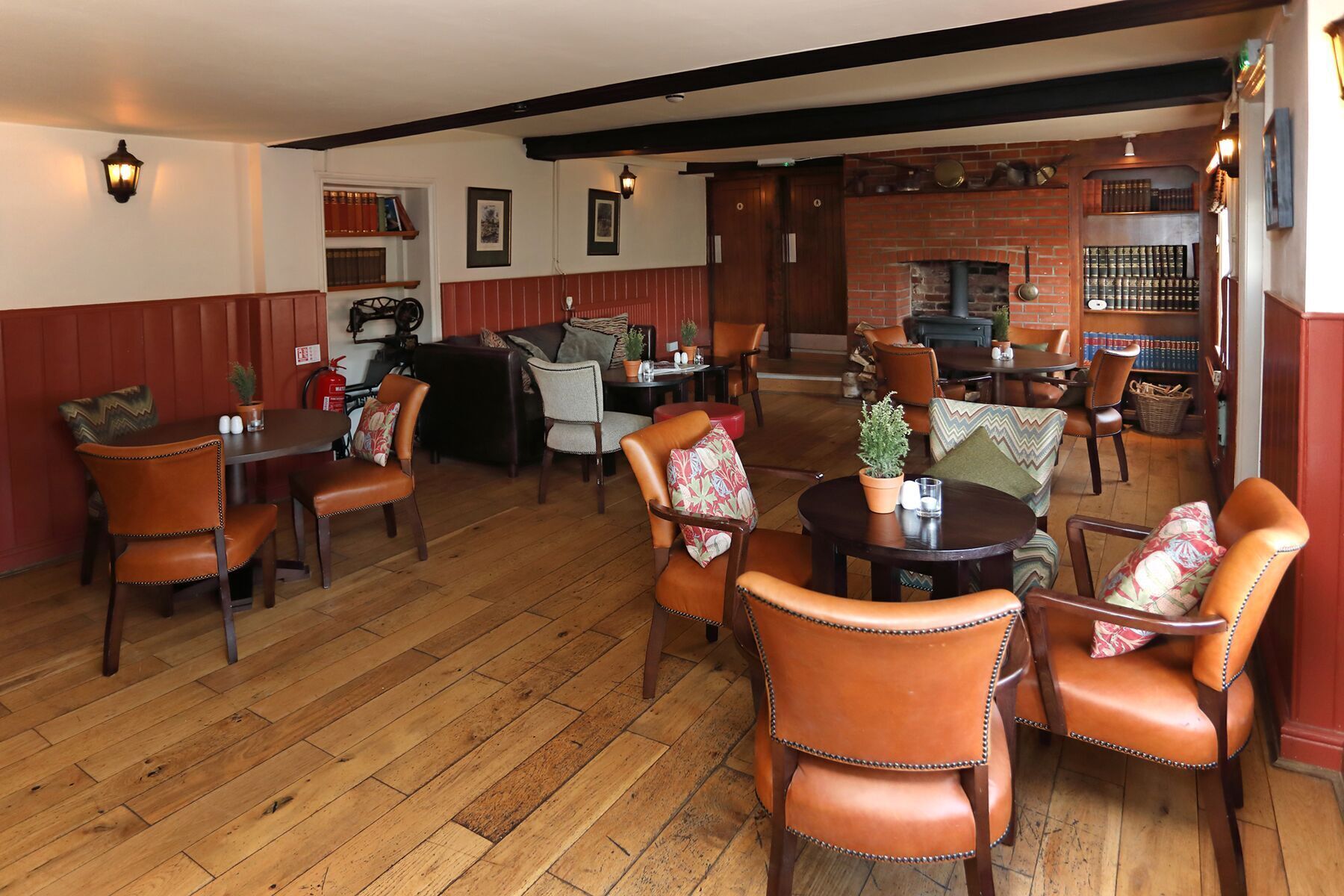 Ein gemütliches Restaurant mit Holzböden, Ledersesseln und einem Kamin aus Ziegelsteinen.