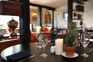A dining table with a candle, salt and pepper shakers, and a potted plant. - The Rising Sun (Norwich)