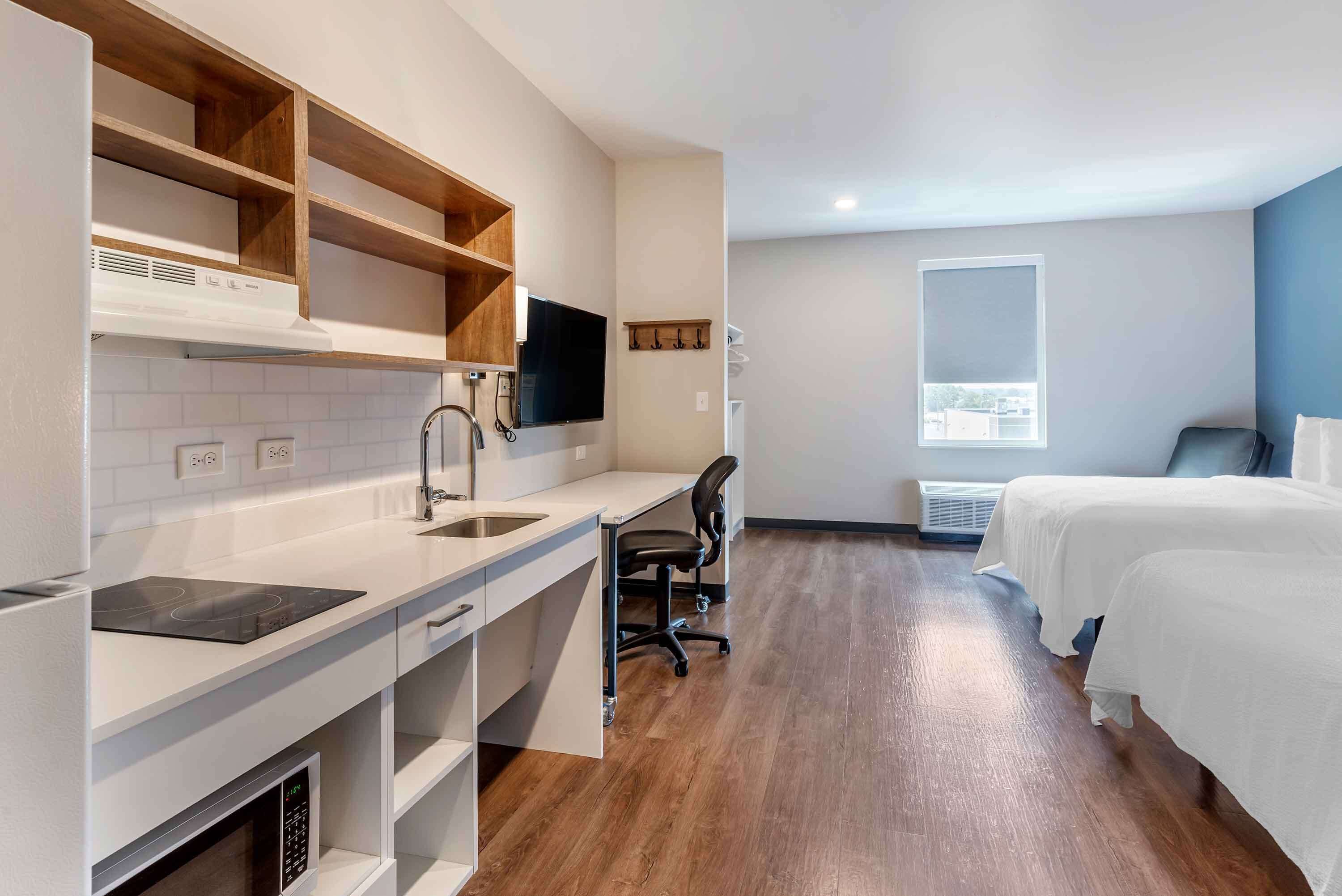 desk, laptop workspace, iron/ironing board, bed sheets