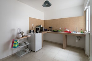 Eine kleine Küche mit Kühlschrank, Mikrowelle und Spüle.