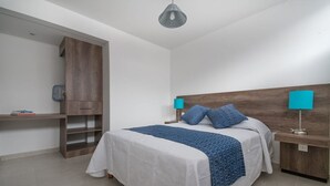 Ein Schlafzimmer mit einem Bett, Nachttischen, einem Kleiderschrank und einer Pendelleuchte.