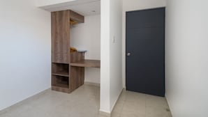A hallway with a dark door, a wooden cabinet with drawers, and a shelf. - JUUB at THE SOUL OF OAXACA (Oaxaca)