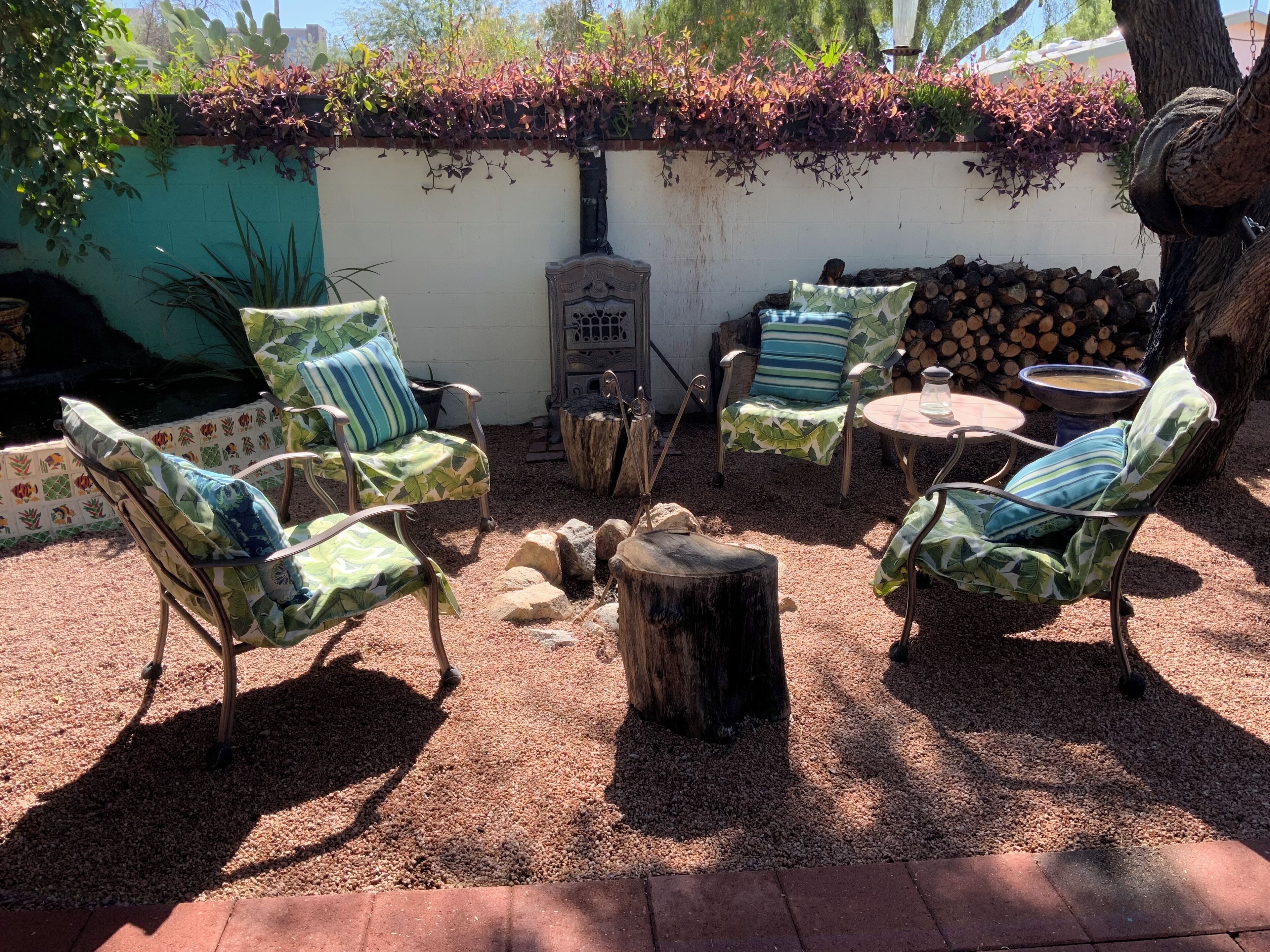 An outdoor seating area with four chairs, a small table, and a fire pit.