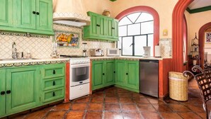Uma cozinha com armários verdes, fogão branco, micro-ondas e máquina de lavar louça.