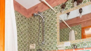 Une salle de bain avec des carreaux décorés, une douche et des meubles en bois.