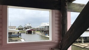 Une vue depuis une fenêtre donnant sur une zone riveraine, avec des bâtiments et un quai.
