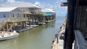 Une propriété située au bord de l’eau, dotée d’un quai, d’un bateau et d’une maison avec un balcon donnant sur l’eau.