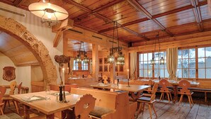 Un interior de madera acogedor con techos altos, decoración rústica y amplios ventanales que ofrecen vistas al exterior.