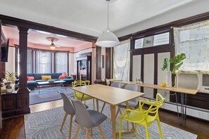 Cozy living area with a dining table for four, fireplace, and large window offering a view of the outdoors.