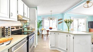 A modern kitchen with white cabinetry, stainless steel appliances, and a central island.