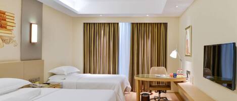 A hotel room with two beds, a desk, a chair, a TV, and a window with curtains.