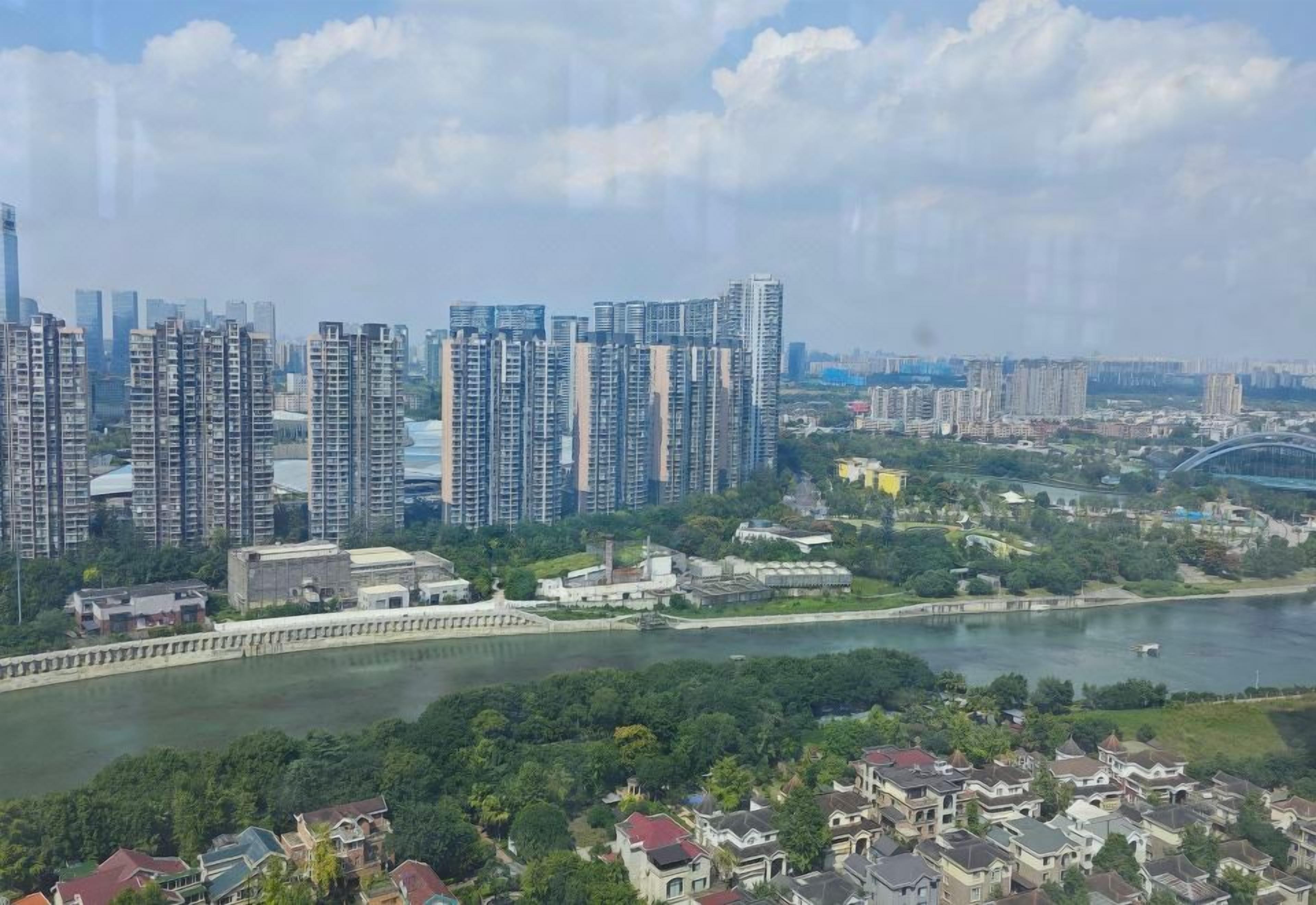 A high-rise residential area with a river and a bridge in the background.