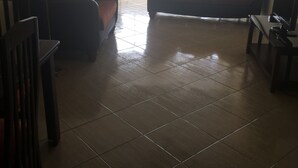 Ein Wohnzimmer mit einer Couch, einem Fernseher und einem Deckenventilator.