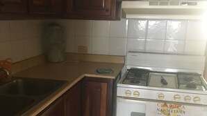 Eine Küche mit Holzausstattung, einem weißen Herd und einem Edelstahlspülbecken.