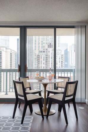 A balcony with a table and chairs, a bottle of wine, and a glass of wine. - Kasa Magnificent Mile Chicago (Chicago)