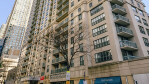 Un edificio alto con varios pisos, ventanas amplias y balcones.