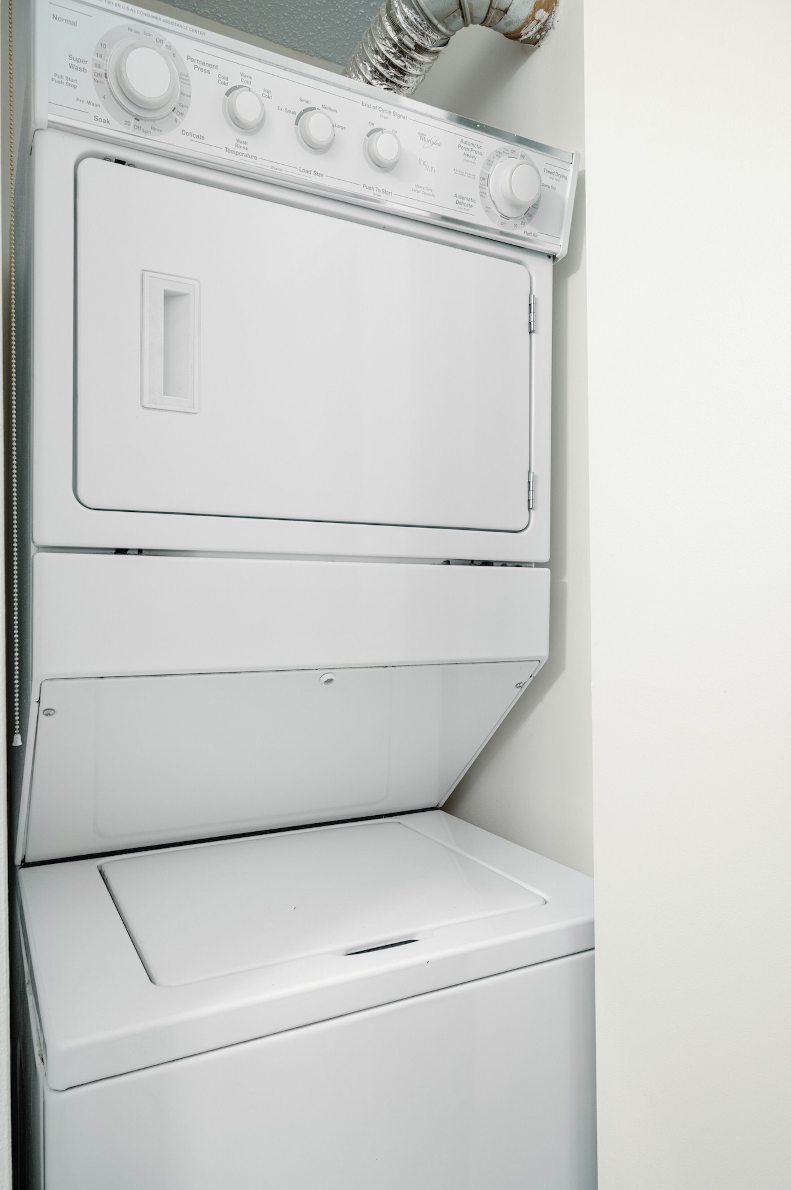 A white stacked washer and dryer unit with control knobs and a front-loading door.