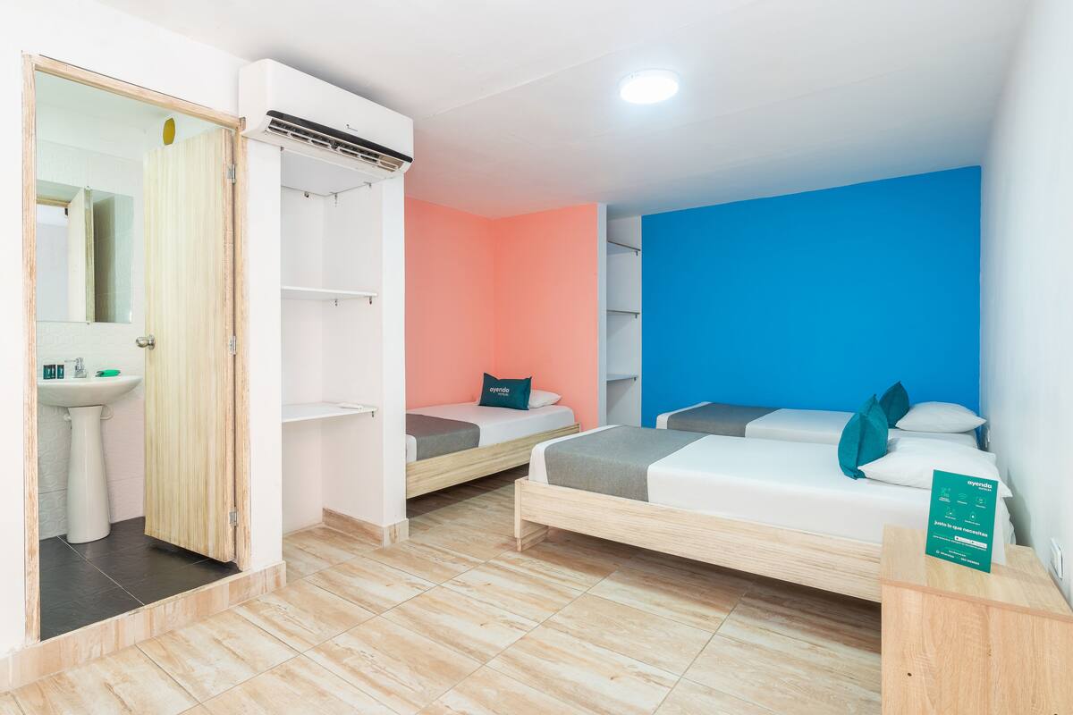 A room with a bed, a small bedside table, a mirror, and a wardrobe.