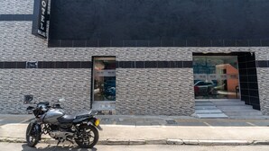 A hotel named "Malaki" with a modern facade, a motorcycle parked in front, and a visible entrance. - Ayenda Malaki (Medellín)