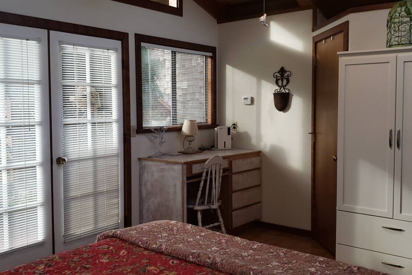 Un dormitorio con cama, escritorio, silla y armario.