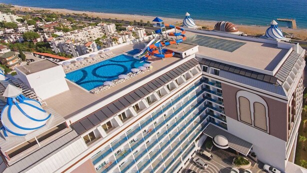 Um navio de cruzeiro com vários decks, área de piscina e um tobogã.